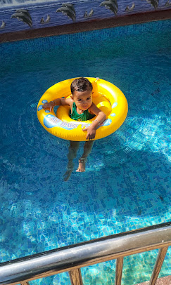 Swimming pool with child enjoying water at resort